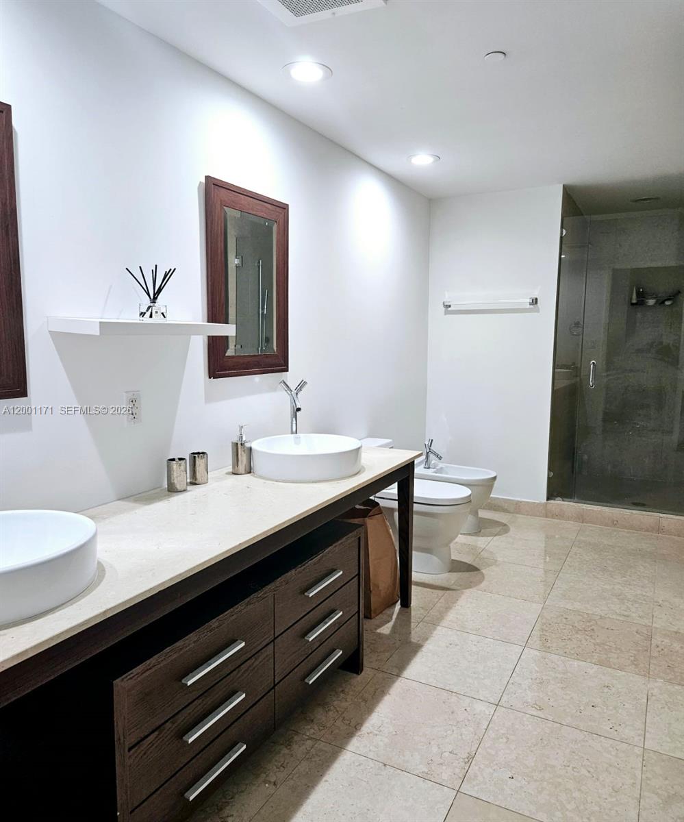475 Brickell Avenue, Unit 2115 Miami, FL 33131 - Photo 12 of 21 a spacious bathroom with a granite countertop sink a toilet and a mirror