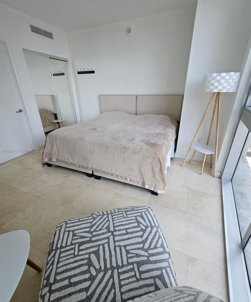 475 Brickell Avenue, Unit 2115 Miami, FL 33131 - Photo 15 of 21 a bedroom with a bed and a mirror