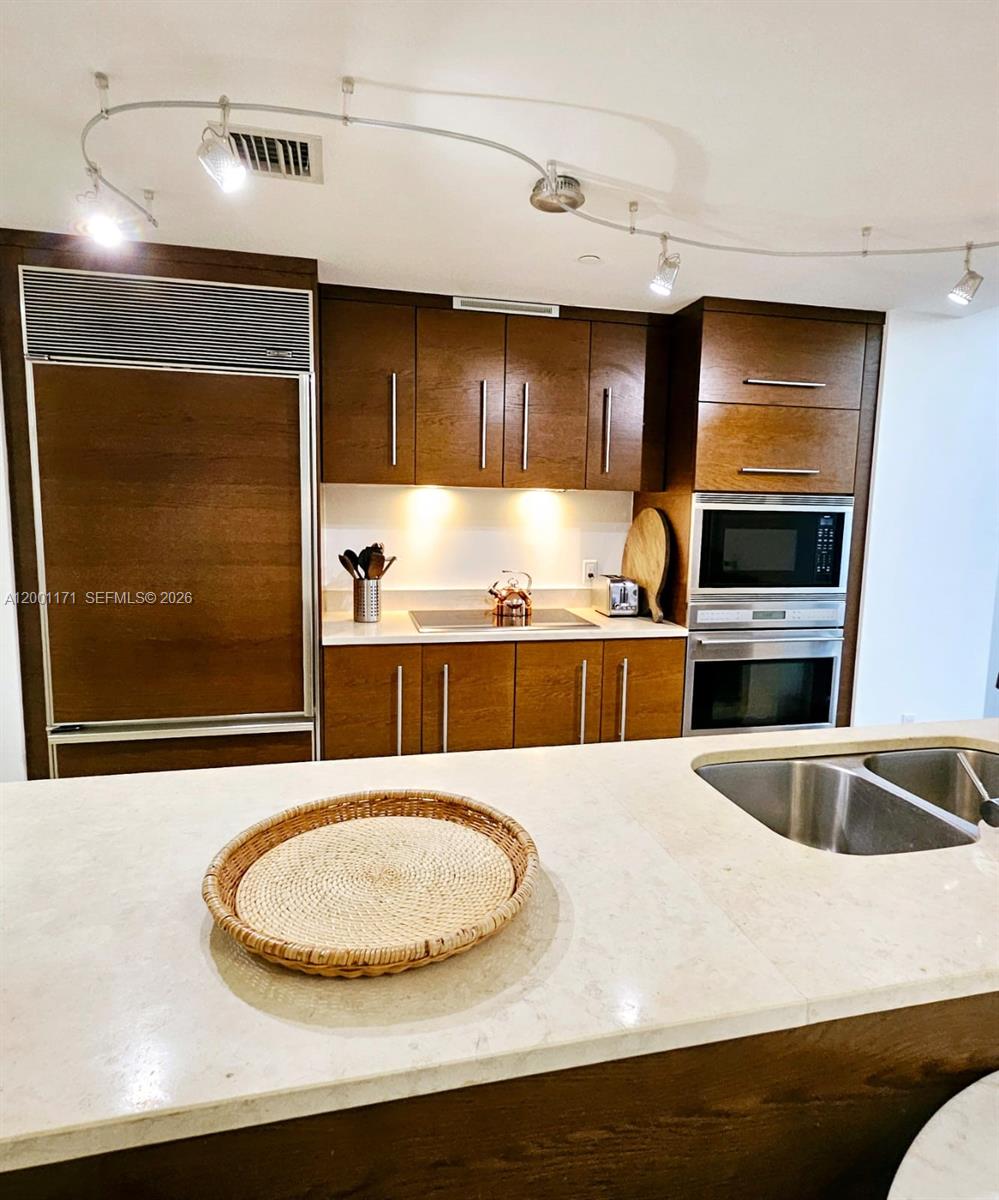 475 Brickell Avenue, Unit 2115 Miami, FL 33131 - Photo 7 of 21 a kitchen with kitchen island a sink a stove and a microwave