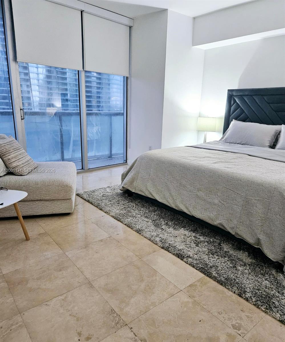 475 Brickell Avenue, Unit 2115 Miami, FL 33131 - Photo 10 of 21 a bedroom with a bed a couch and cabinet