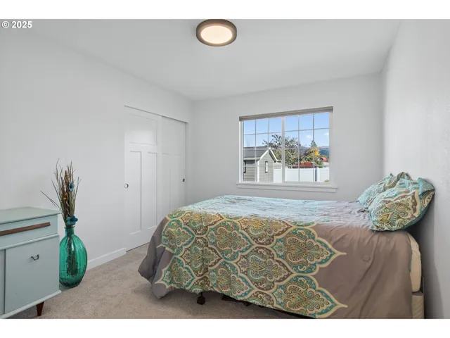 a bedroom with a bed and a painting on the wall