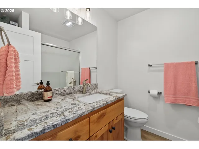 a bathroom with a granite countertop sink a toilet and a mirror