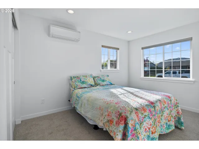 a bedroom with a bed and windows