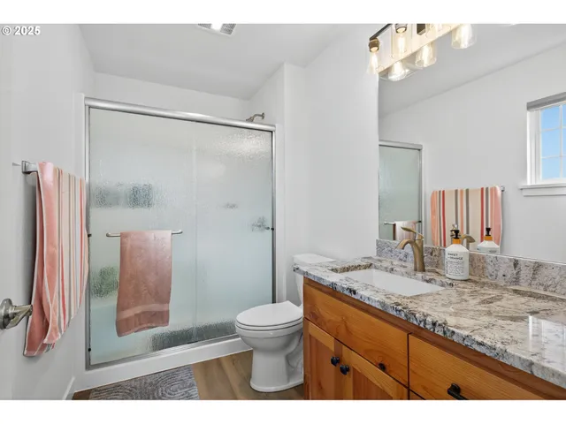 a bathroom with a granite countertop sink toilet and shower