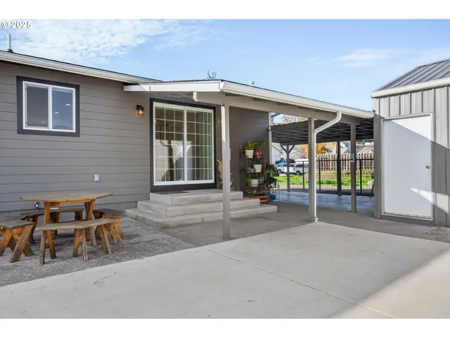 a backyard of a house with table and chairs