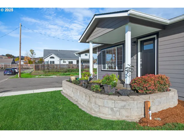 a front view of a house with a yard and potted plants