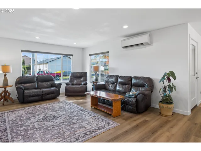 a living room with furniture a wooden floor and a potted plant