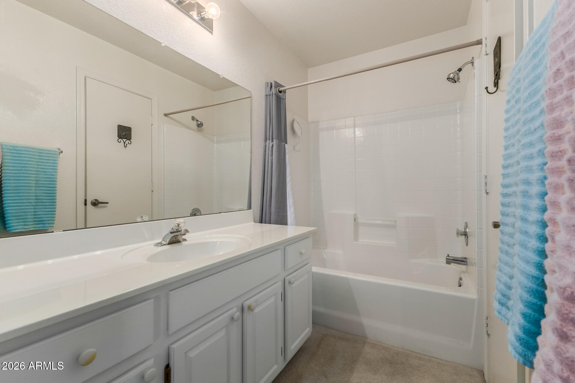 14300 West Bell Road, Unit 311 Surprise, AZ 85374 - Photo 15 of 50 a bathroom with a shower sink vanity and mirror