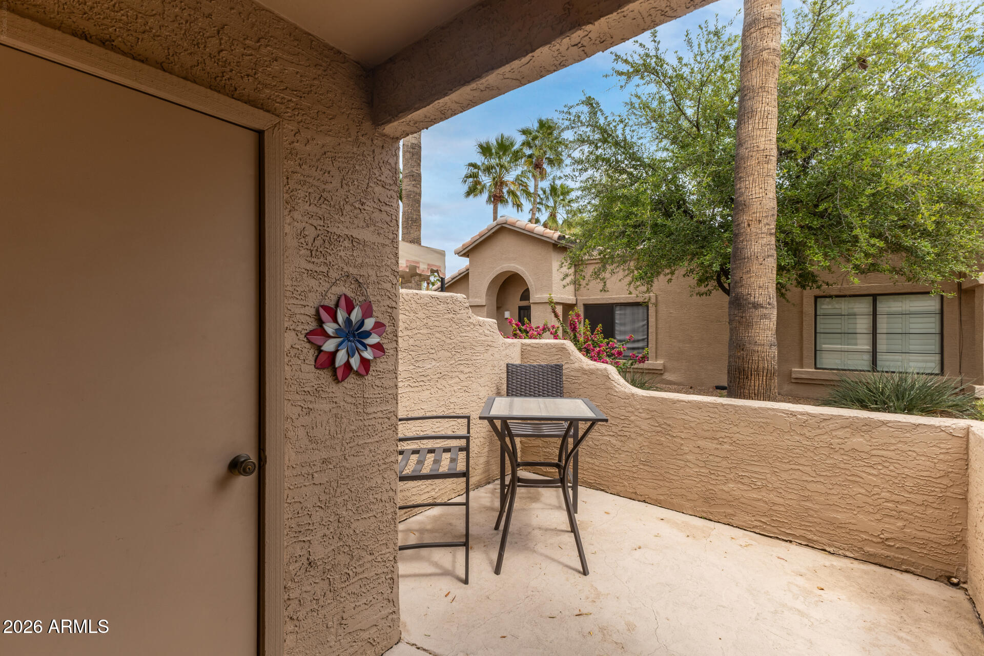 14300 West Bell Road, Unit 311 Surprise, AZ 85374 - Photo 20 of 50 a view of a patio with table and chairs and potted plants