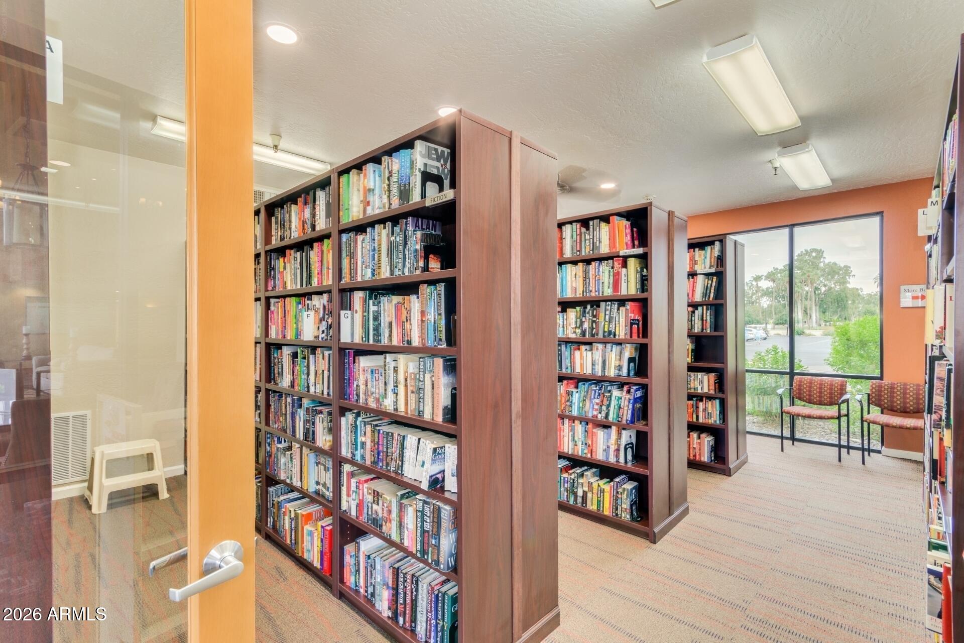 14300 West Bell Road, Unit 311 Surprise, AZ 85374 - Photo 25 of 50 a living room with a book shelf and a book shelf