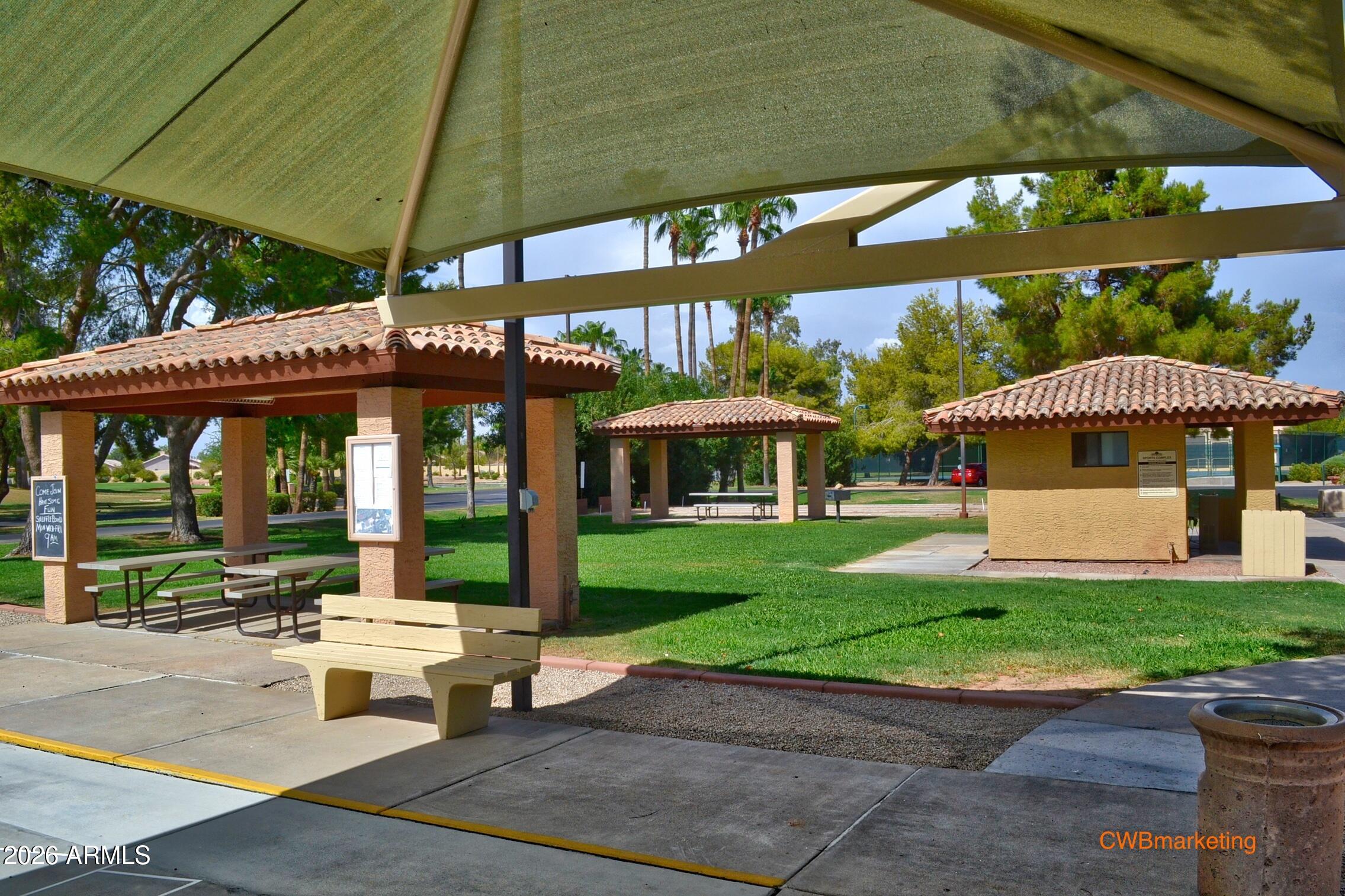 14300 West Bell Road, Unit 311 Surprise, AZ 85374 - Photo 43 of 50 a view of a table and chairs under an umbrella in front of house