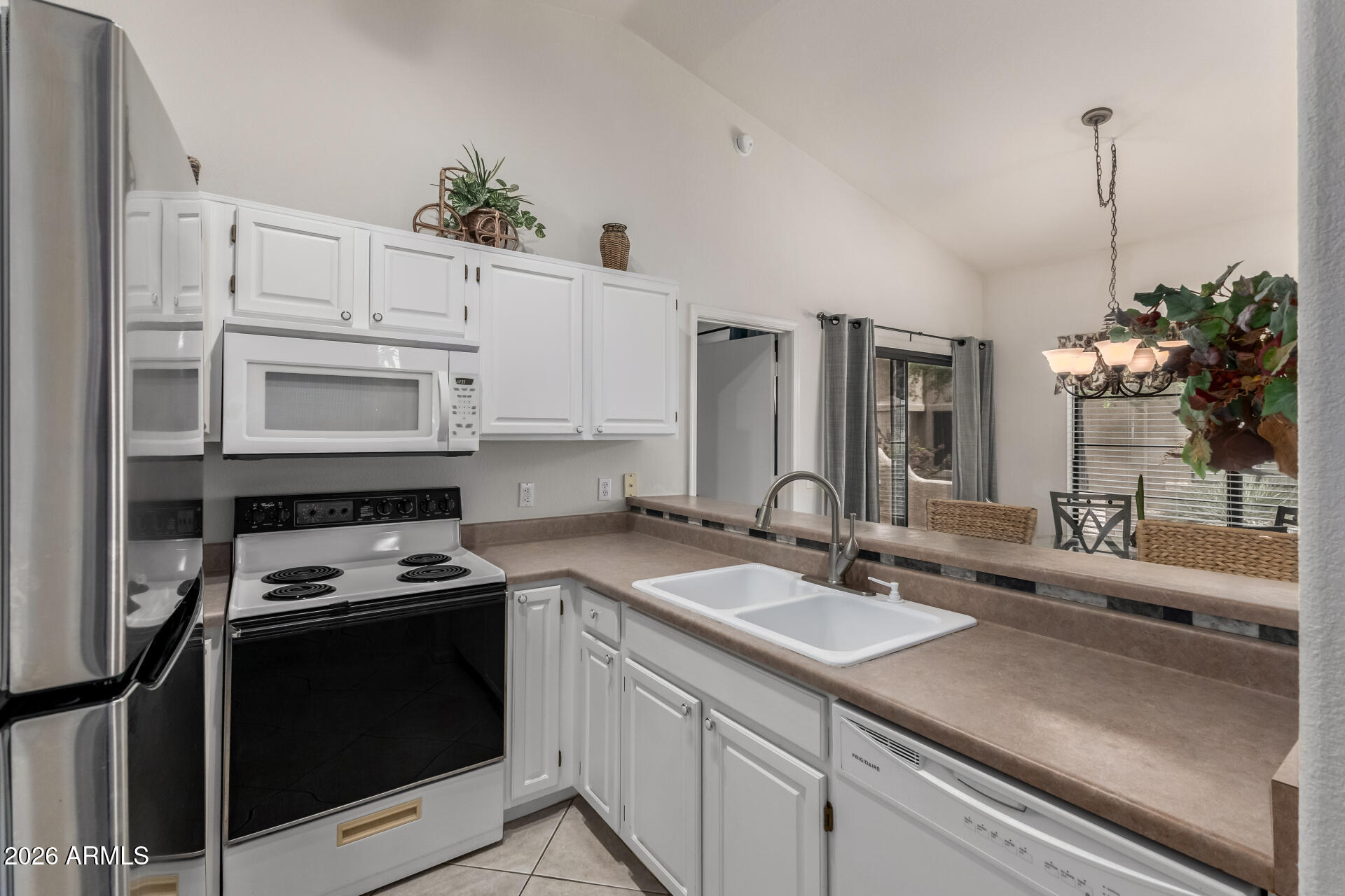 14300 West Bell Road, Unit 311 Surprise, AZ 85374 - Photo 9 of 50 a kitchen with kitchen island granite countertop a sink stainless steel appliances and cabinets