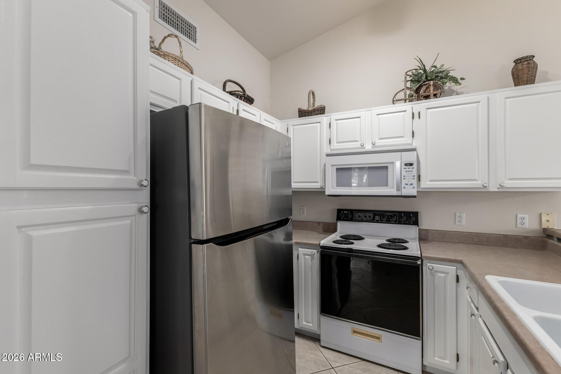 14300 West Bell Road, Unit 311 Surprise, AZ 85374 - Photo 10 of 50 a kitchen with stainless steel appliances a refrigerator sink and microwave