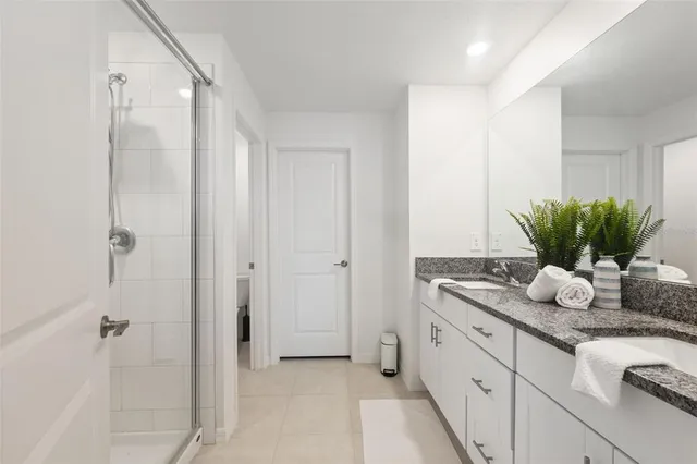 a bathroom with a granite countertop sink a mirror and a shower