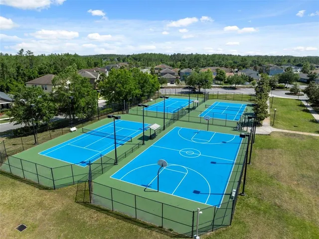 a view of a tennis ground with large trees