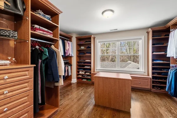 a view of walk in closet with clothes and shoes