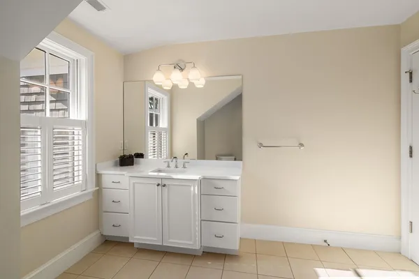 a spacious bathroom with a double vanity sink a mirror and a bathtub