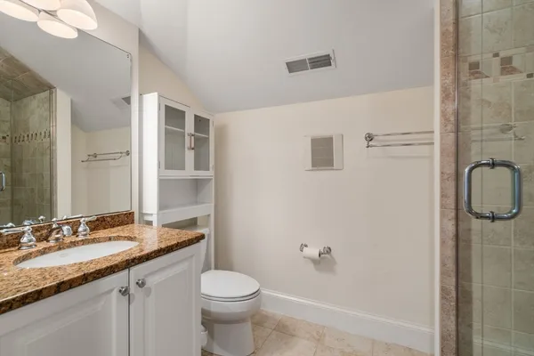 a bathroom with a granite countertop sink toilet and shower