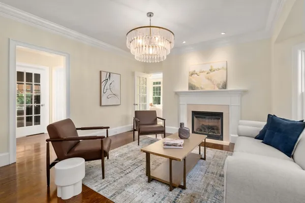 a living room with furniture a chandelier and a fireplace