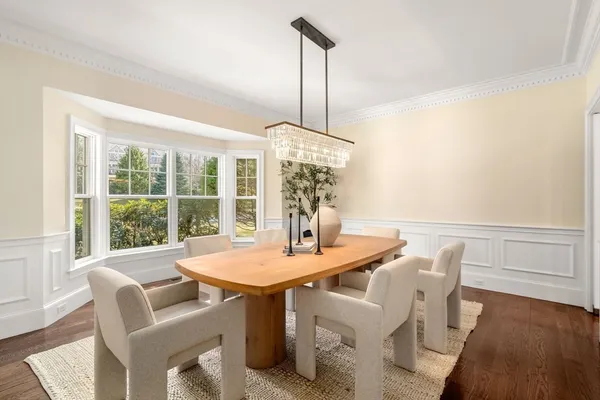 a dining room with furniture a chandelier and wooden floor