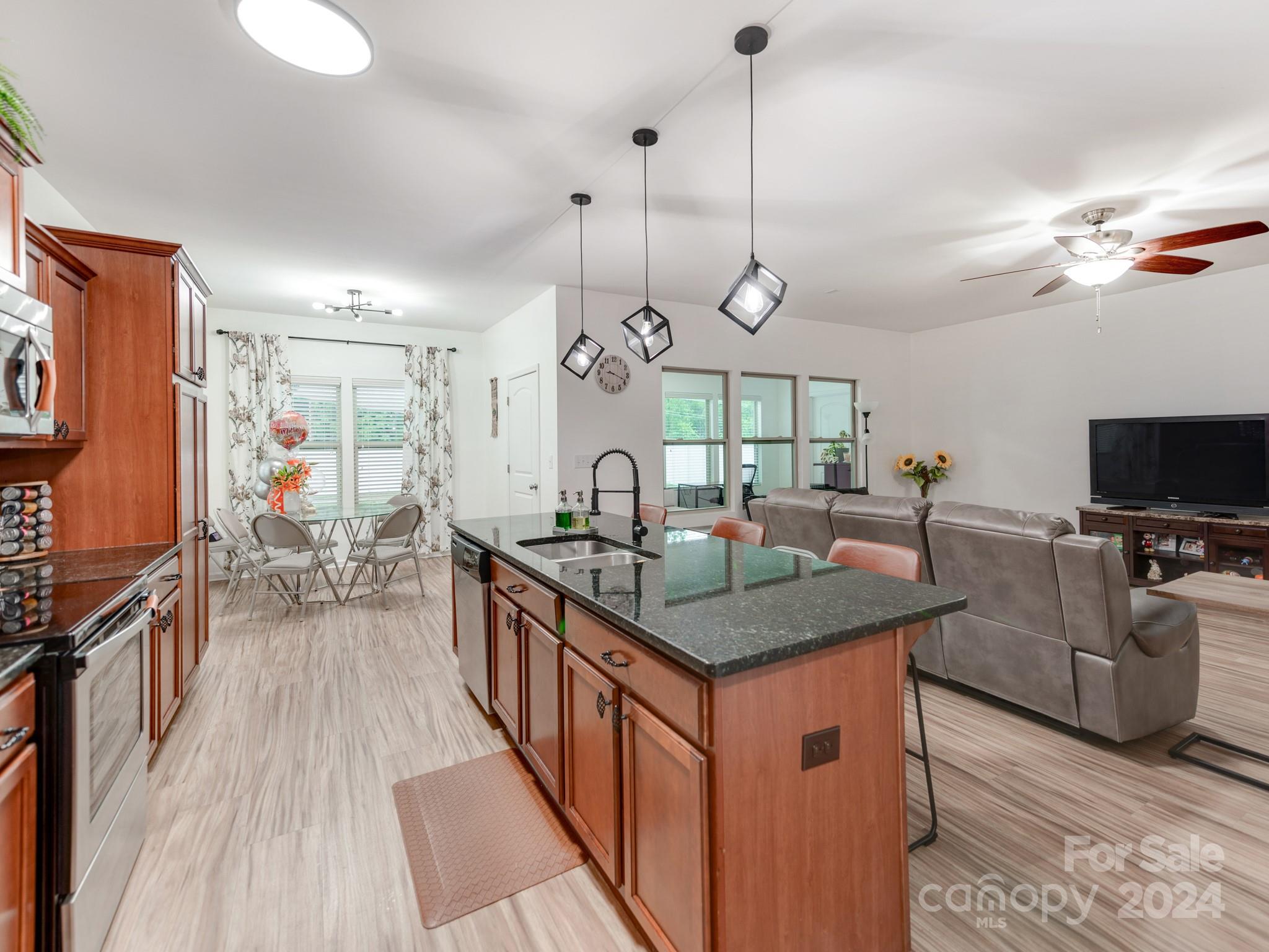 8080 Bryson Road Indian Land, SC 29707 - Photo 10 of 38 a kitchen with stainless steel appliances granite countertop a sink a stove top oven a counter space and living room view