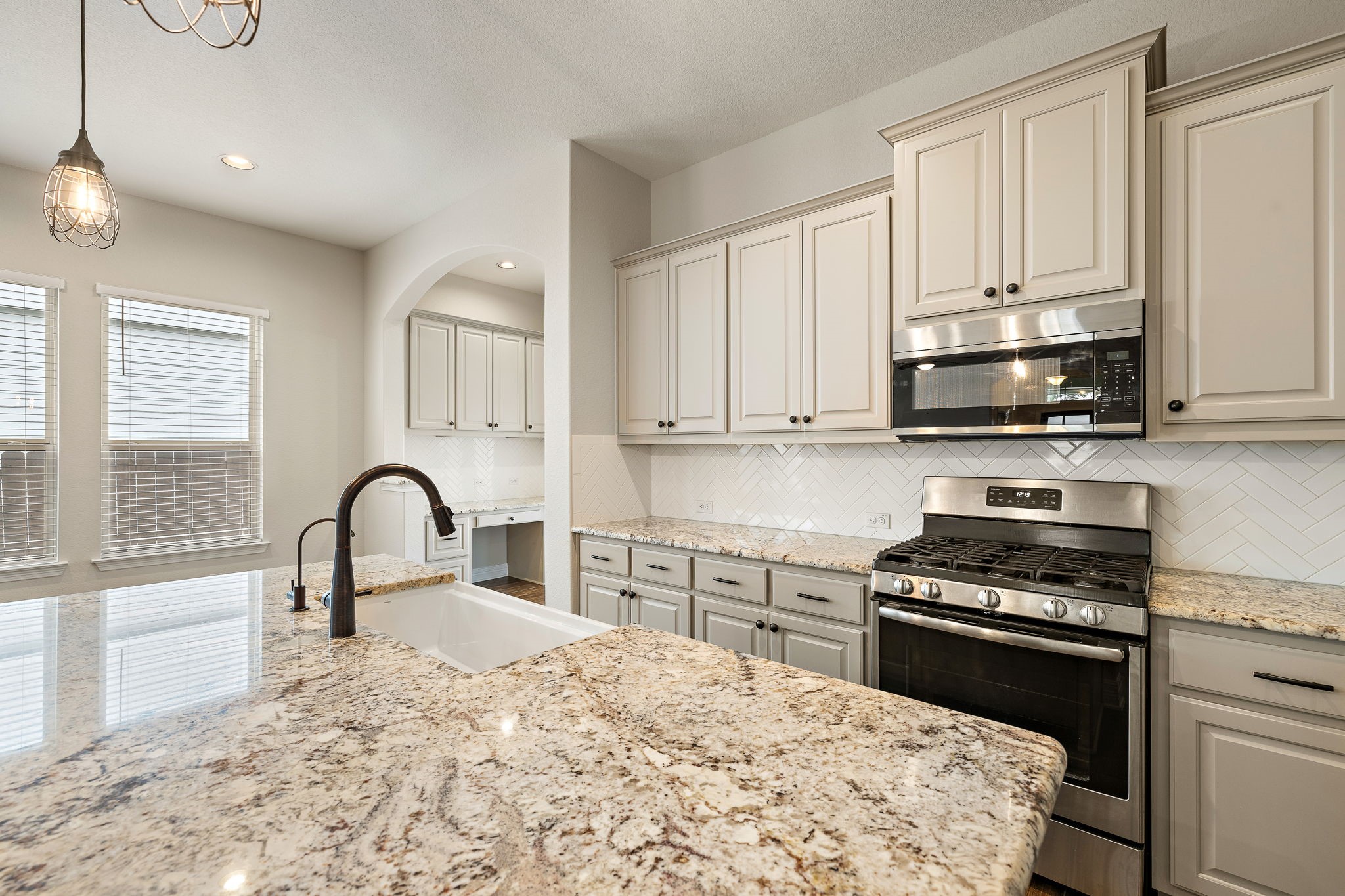 2137 Ringstaff Road Leander, TX 78641 - Photo 9 of 40 Enjoy hosting family and friends in this gorgeous kitchen featuring granite countertops with designer backsplash and farmhouse sink.