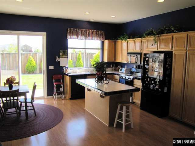 1670 Cattlemen Court Reno, NV 89521 - Photo 4 of 12 a kitchen with stainless steel appliances granite countertop a stove a refrigerator a sink a dining table and chairs