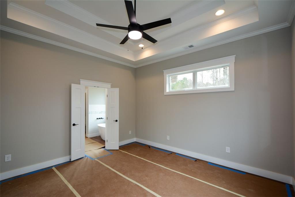 171 Field Stone Circle Jasper, GA 30143 - Photo 22 of 71 en empty room with windows and ceiling fan