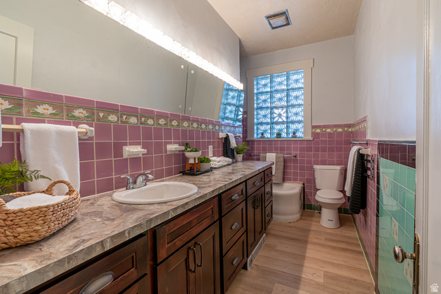 33 North 200 East Logan, UT 84321 - Photo 17 of 54 Bathroom featuring a wainscoted wall, tile walls, vanity, and light wood-style floors