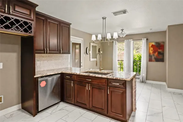 a kitchen with stainless steel appliances granite countertop a sink and a refrigerator