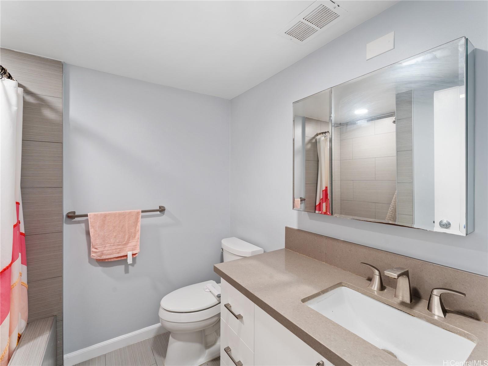 4300 Waialae Avenue, Unit B601 Honolulu, HI 96816 - Photo 13 of 18 a bathroom with a sink vanity mirror and toilet