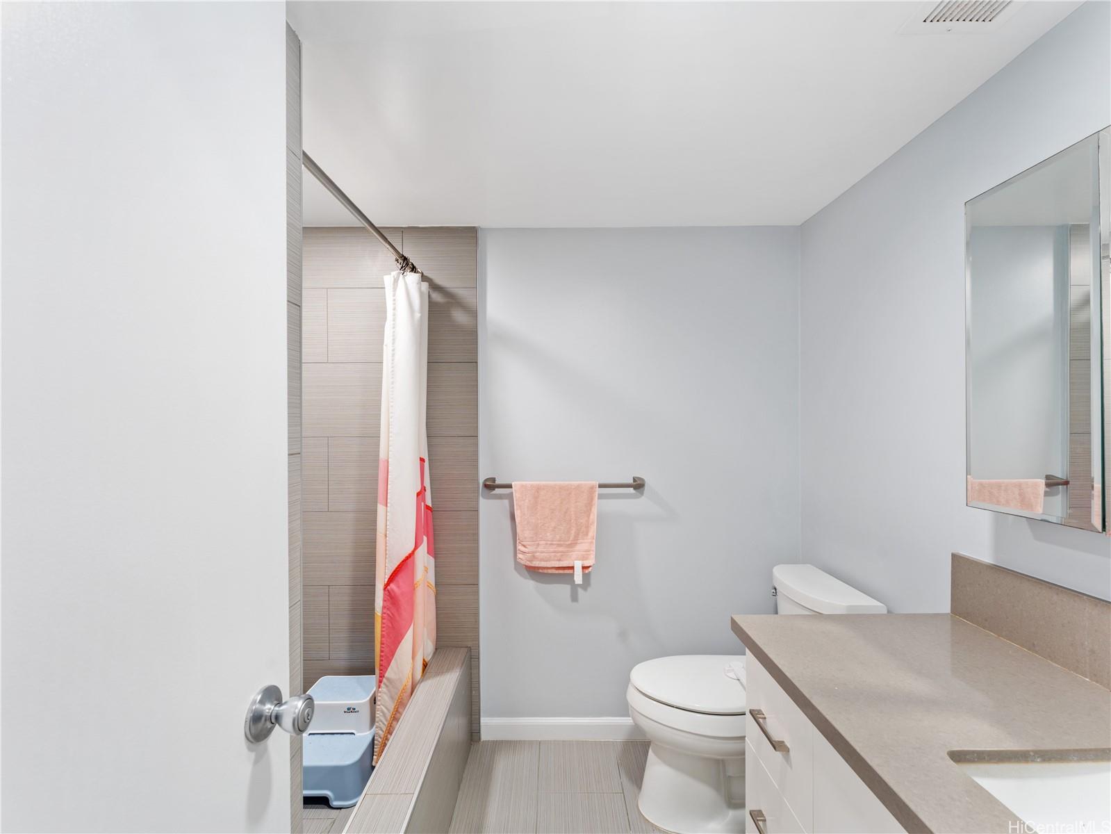 4300 Waialae Avenue, Unit B601 Honolulu, HI 96816 - Photo 14 of 18 a bathroom with a sink toilet vanity and mirror