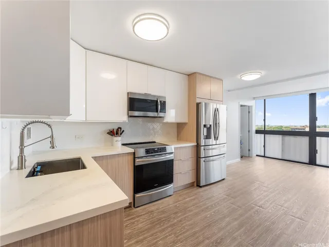 a kitchen with stainless steel appliances granite countertop a refrigerator stove top oven and sink