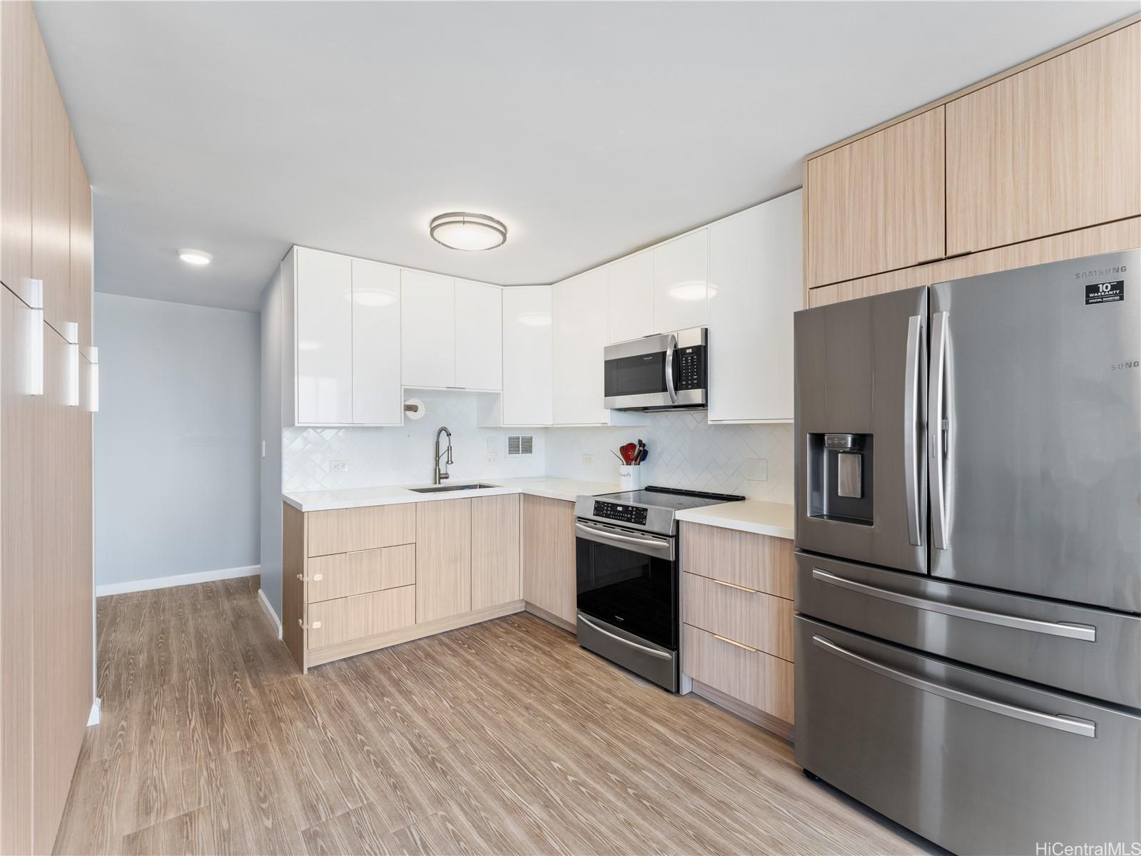 4300 Waialae Avenue, Unit B601 Honolulu, HI 96816 - Photo 6 of 18 a kitchen with a refrigerator stainless steel appliances wooden floor and cabinets