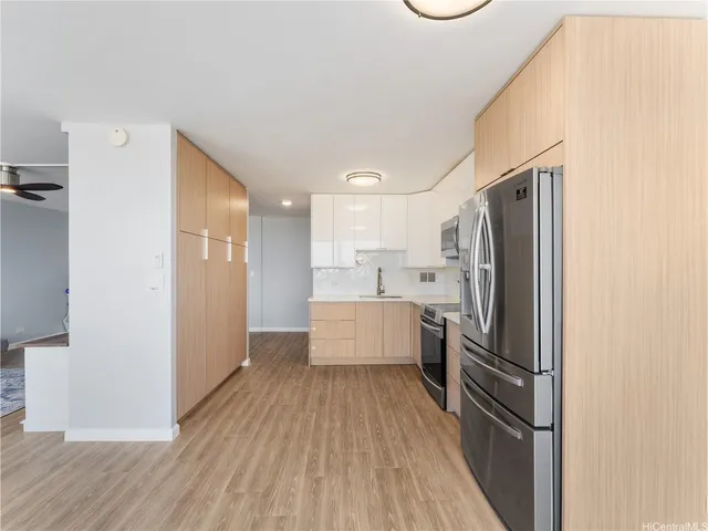 a kitchen with a refrigerator and white cabinets
