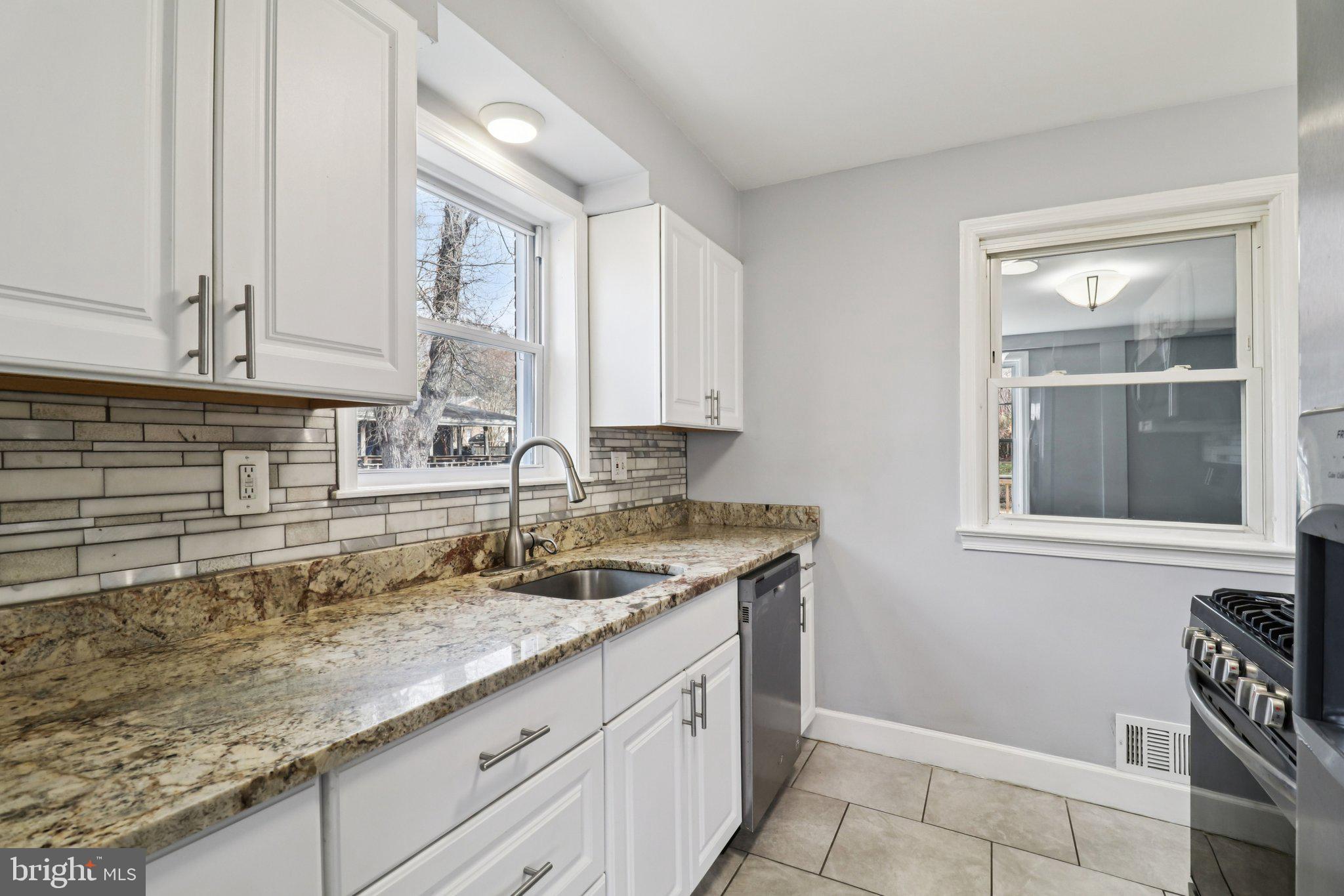 11515 Orebaugh Avenue Silver Spring, MD 20902 - Photo 13 of 69 a kitchen with granite countertop a sink a stove and cabinets