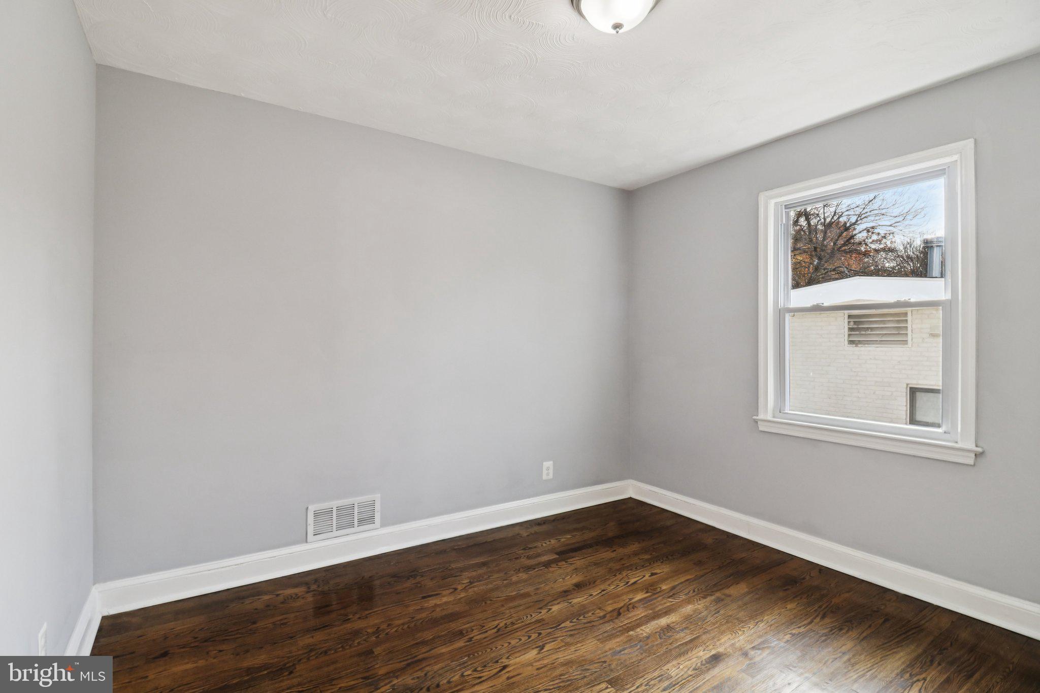 11515 Orebaugh Avenue Silver Spring, MD 20902 - Photo 17 of 69 a view of an empty room with wooden floor and a window