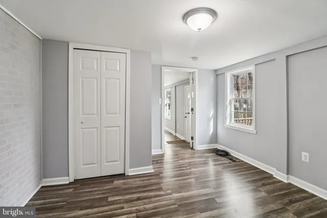 an empty room with closet and windows