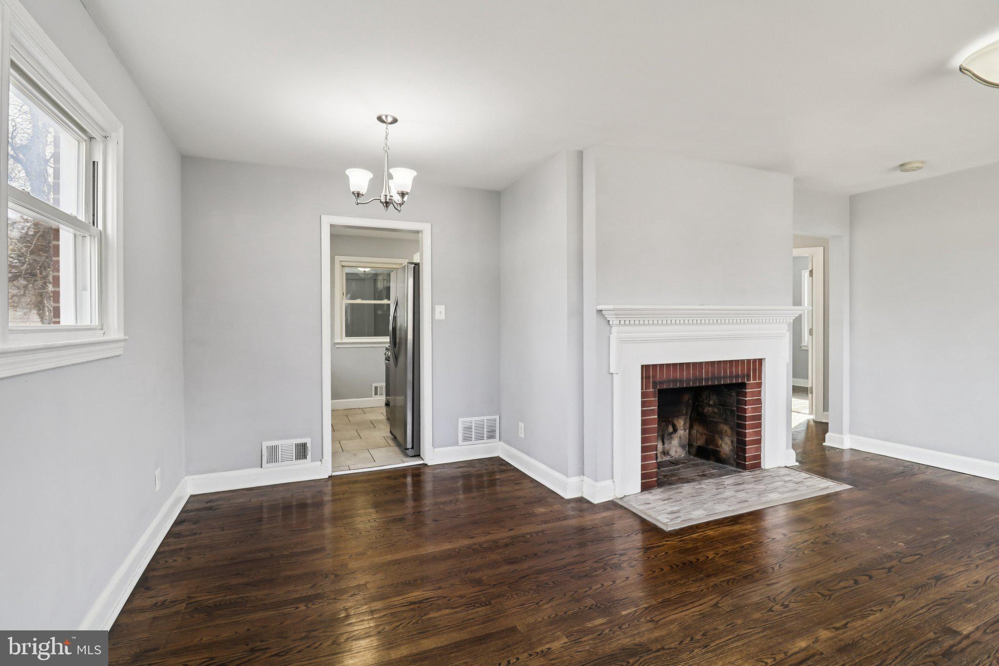 11515 Orebaugh Avenue Silver Spring, MD 20902 - Photo 8 of 69 an empty room with wooden floor fireplace and windows