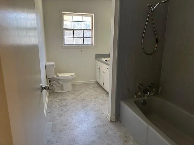 a bathroom with a granite countertop toilet a sink and bathtub