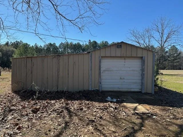 a view of a small barn with wooden fence