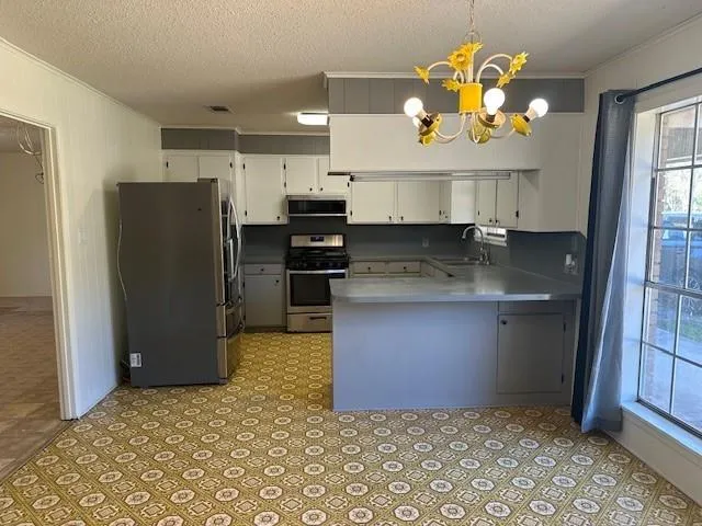 a kitchen with stainless steel appliances granite countertop a refrigerator a stove a sink and a oven