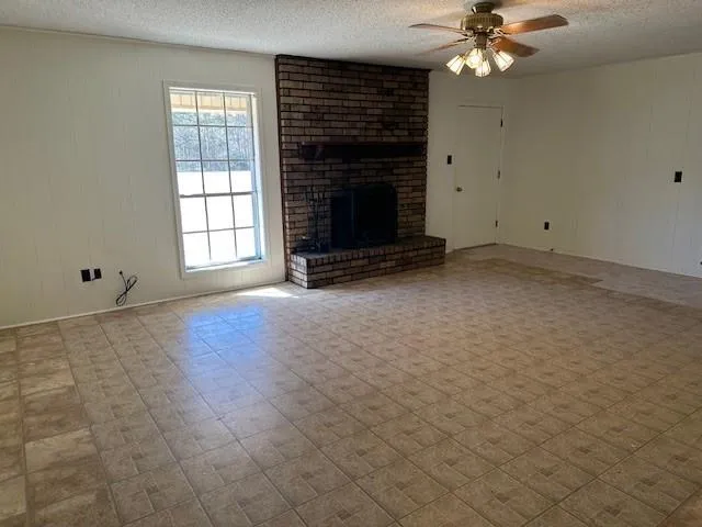 an empty room with windows and fireplace