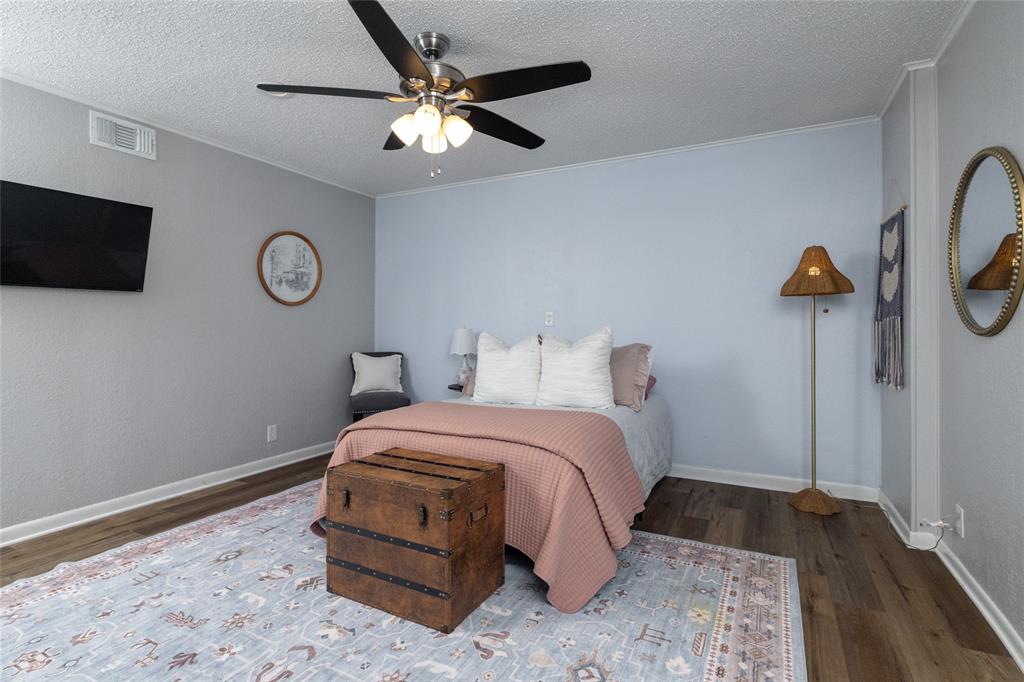 205 Timberlake Drive Azle, TX 76020 - Photo 24 of 40 a bedroom with a bed and a chandelier