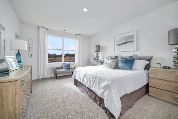 a spacious bedroom with a bed and a window