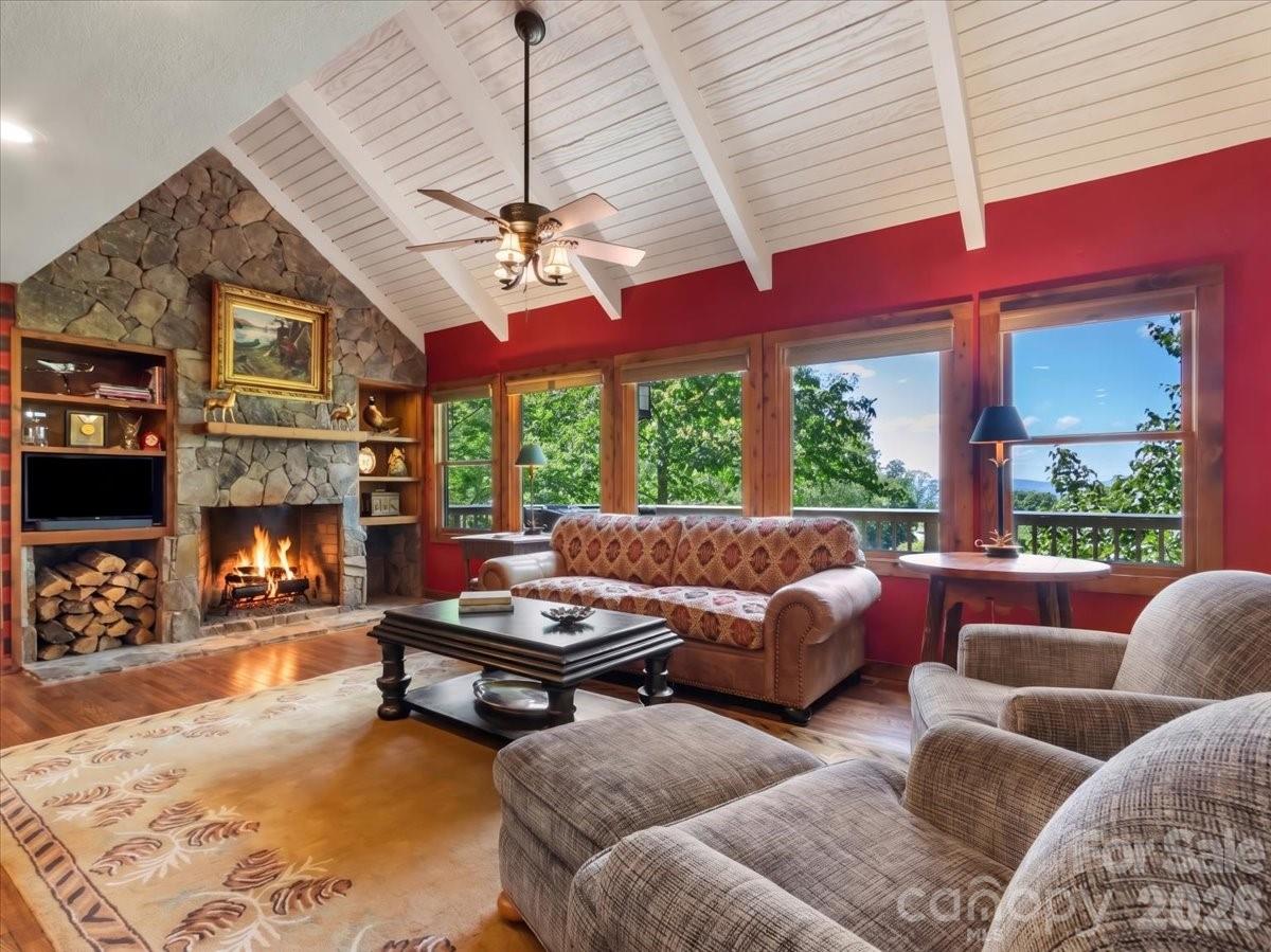 121 Ivy Ridge Road Burnsville, NC 28714 - Photo 7 of 48 a living room with furniture a fireplace and a chandelier