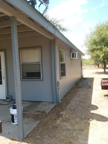 a backyard of a house with table and chairs