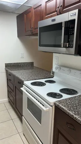 a kitchen with granite countertop a stove and a microwave