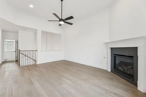 a view of an empty room with a fireplace and a window