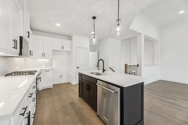 a kitchen with a sink stove and white cabinets